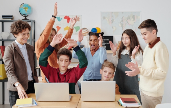 Die Lehrerin und Kinder in einem Schulzimmer.