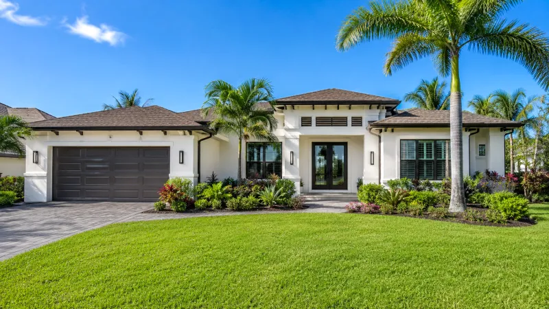 Modernes Haus in Südwestflorida mit tropischer Bepflanzung unter blauem Himmel